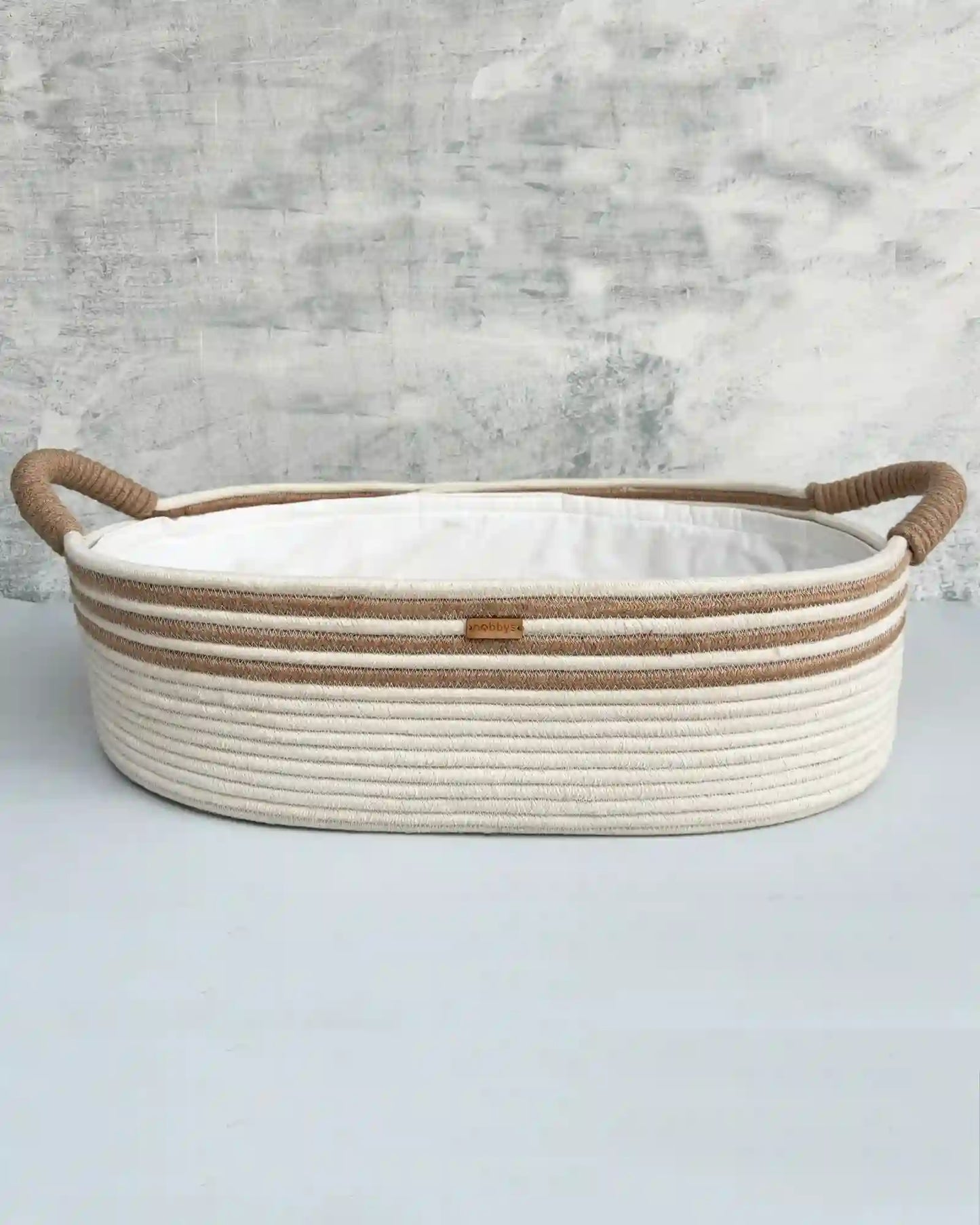 Handcrafted baby diaper changing basket in cream and caramel tones with ultra-soft aloe vera cushioning for maximum comfort