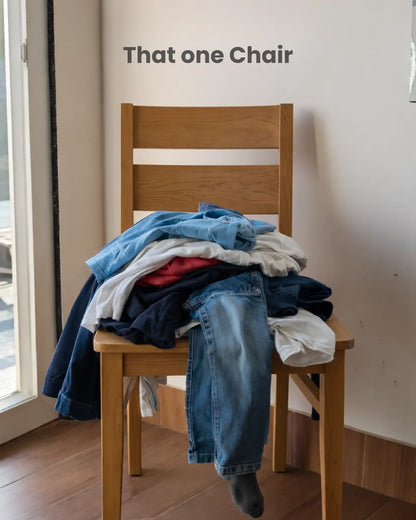 wooden chair with pile of clothes
